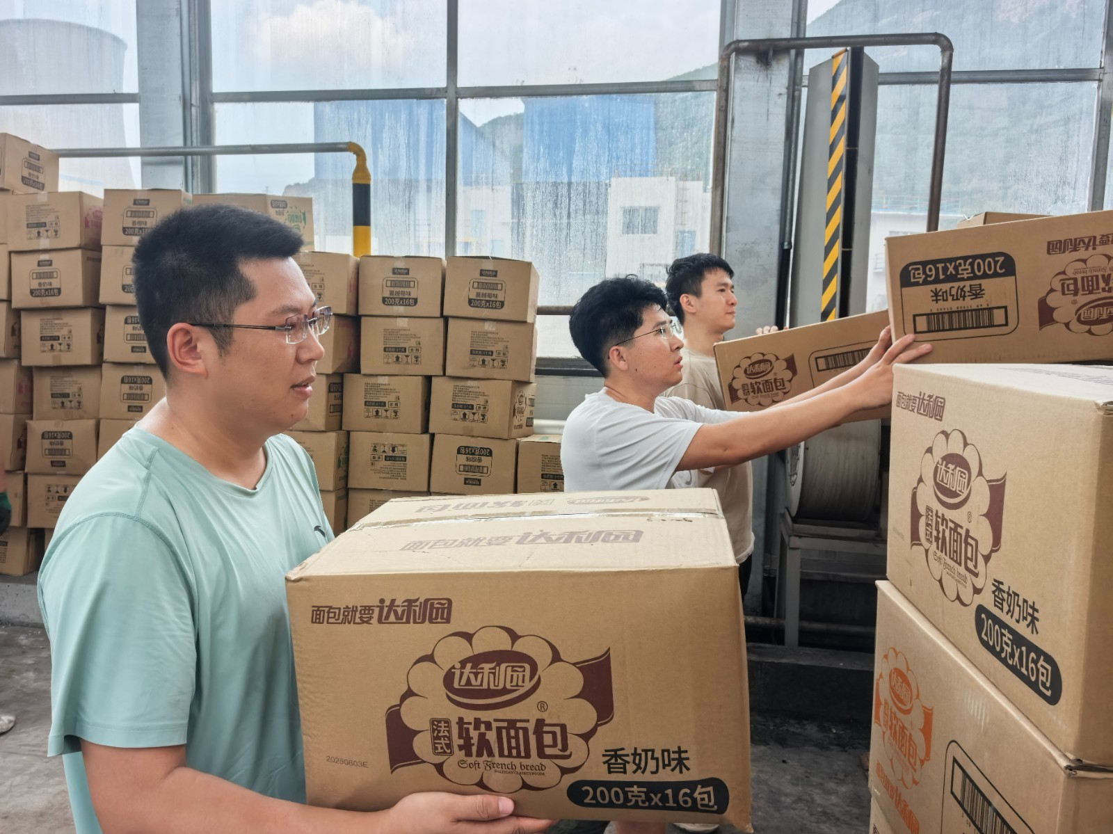 图为青年突击队员接卸兄弟单位支援物资 摄:丛野