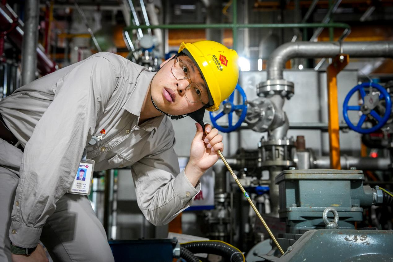图为北仑电厂巡检员正在用听棒了解设备电机运行情况
